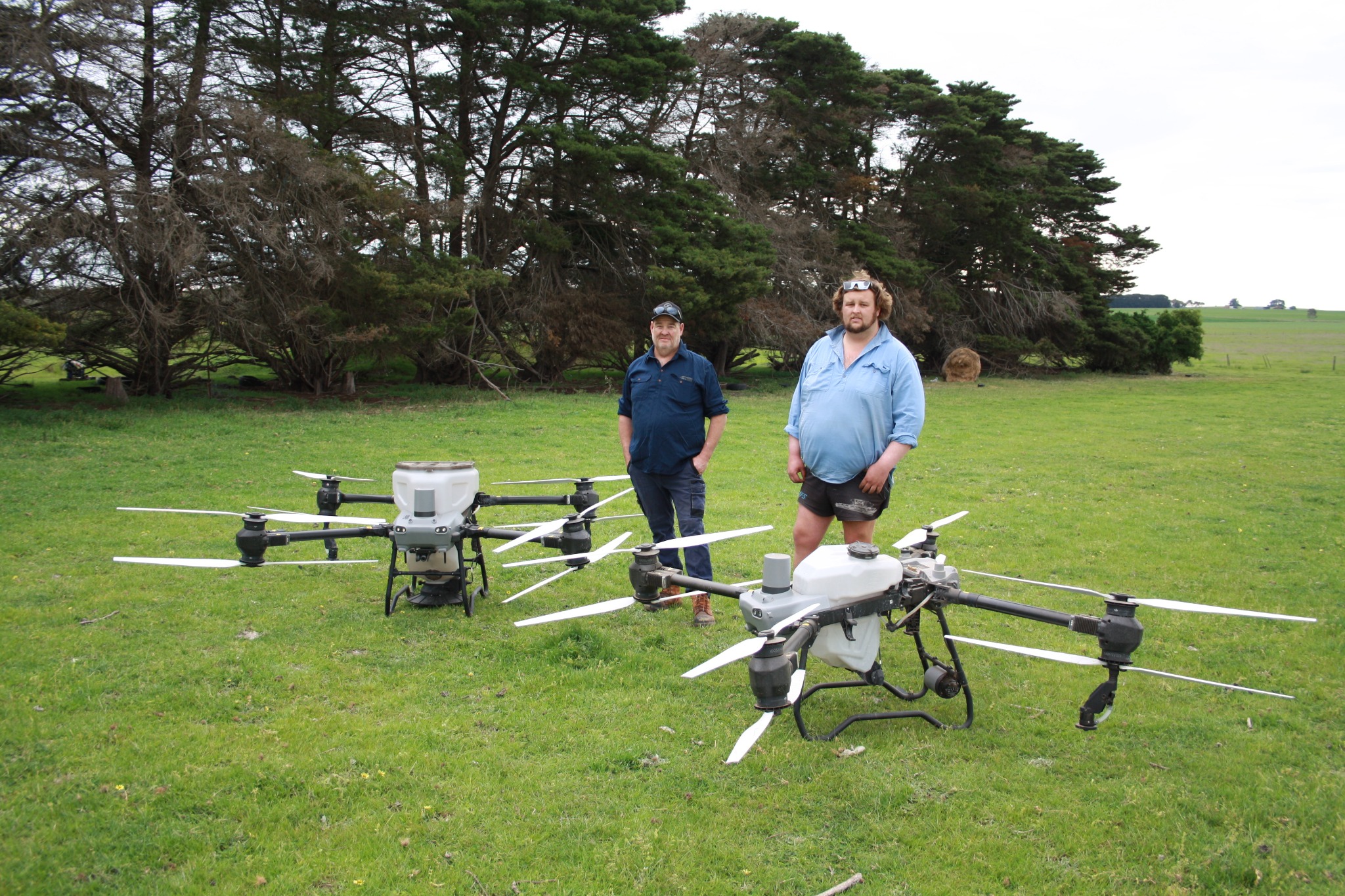 Geoff and Josh Leigh with their two DJI Agras T50 drones in a Winchelsea paddock